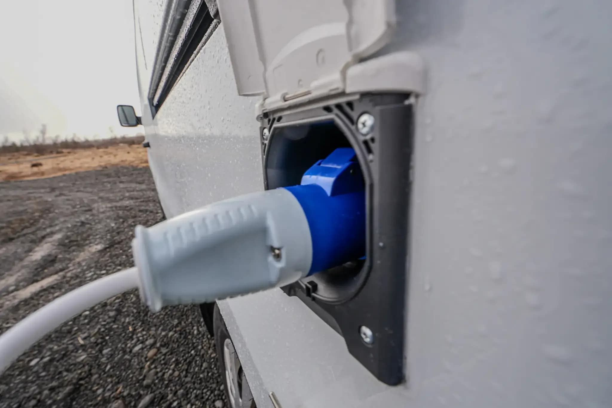 Off-grid campervan power system in Iceland charging multiple devices including laptop, drone, and camera batteries