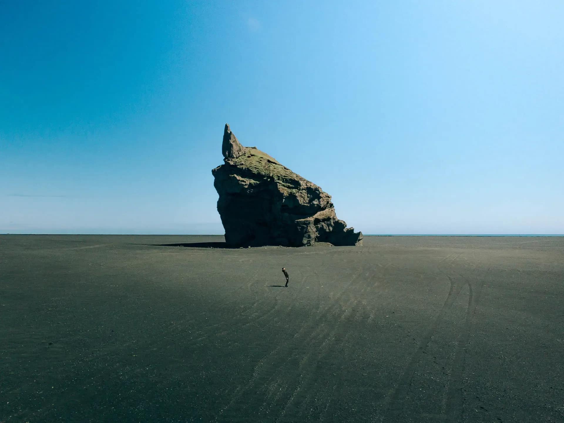 Campervan parked on a remote Icelandic coastline, showing how road trip travel can reduce costs when exploring Iceland in USD
