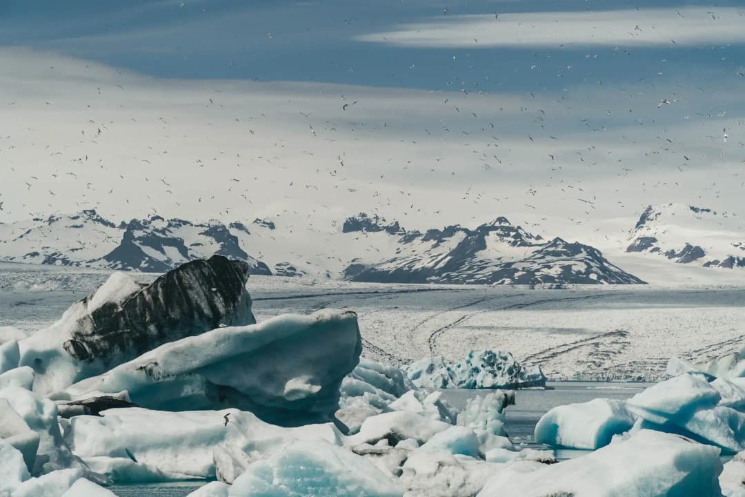 杰古沙龙冰河湖里蓝色的冰山，背后是瓦特纳冰川国家公园的雪山