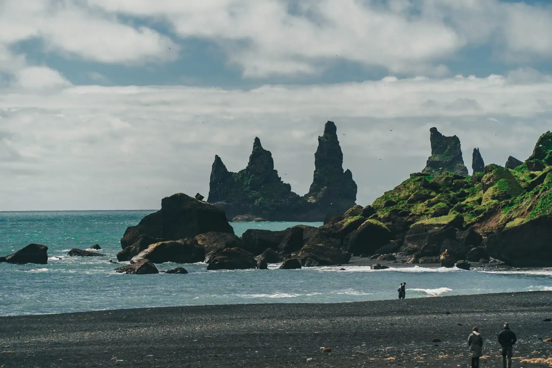 Reynisdrangar sea stacks rising from the ocean at Reynisfjara black sand beach near Vík in South Iceland during a scenic campervan road trip