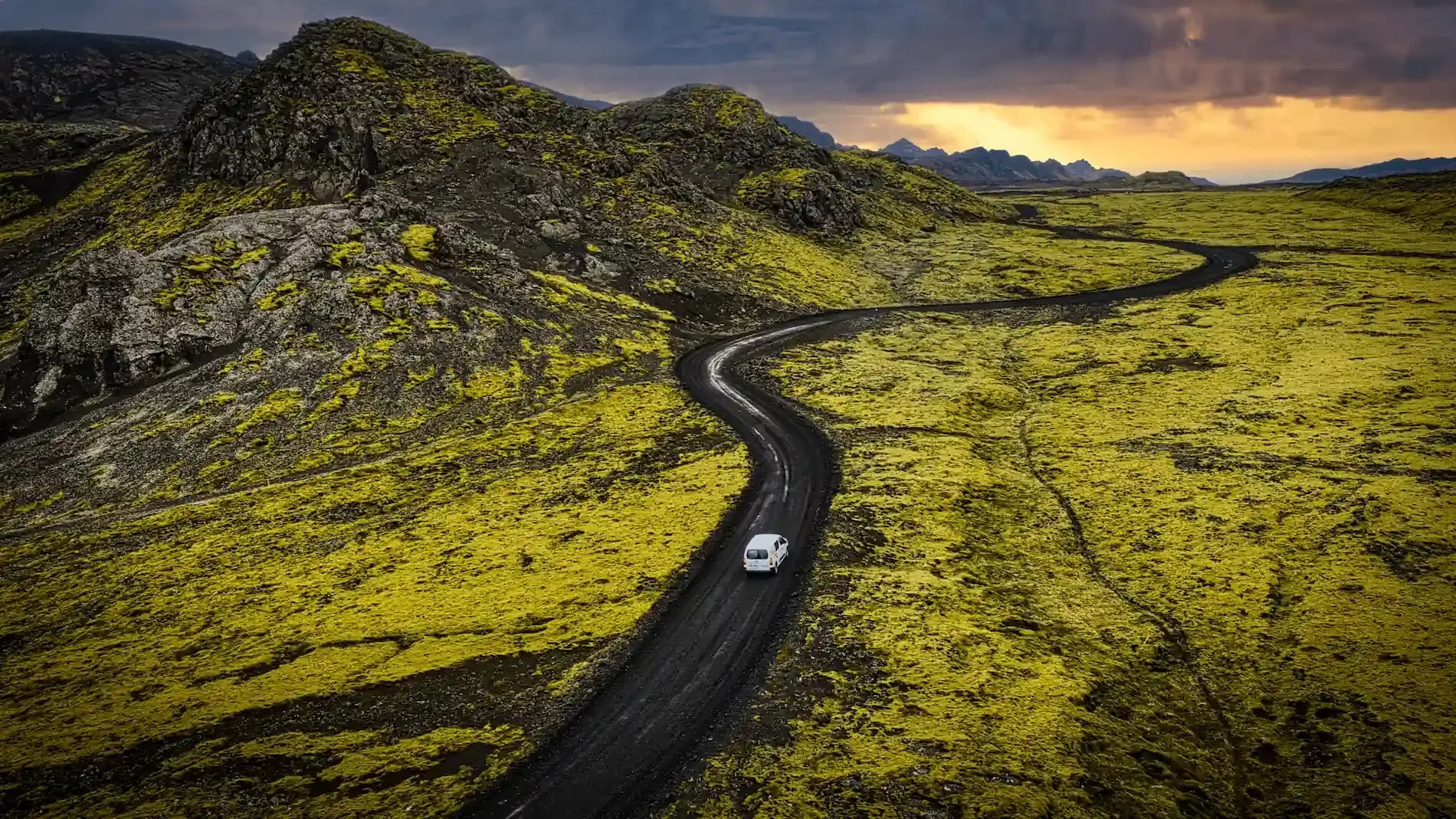 A campervan exploring the dramatic landscapes of the Westfjords, surrounded by volcanic terrain and vibrant green moss in Iceland.