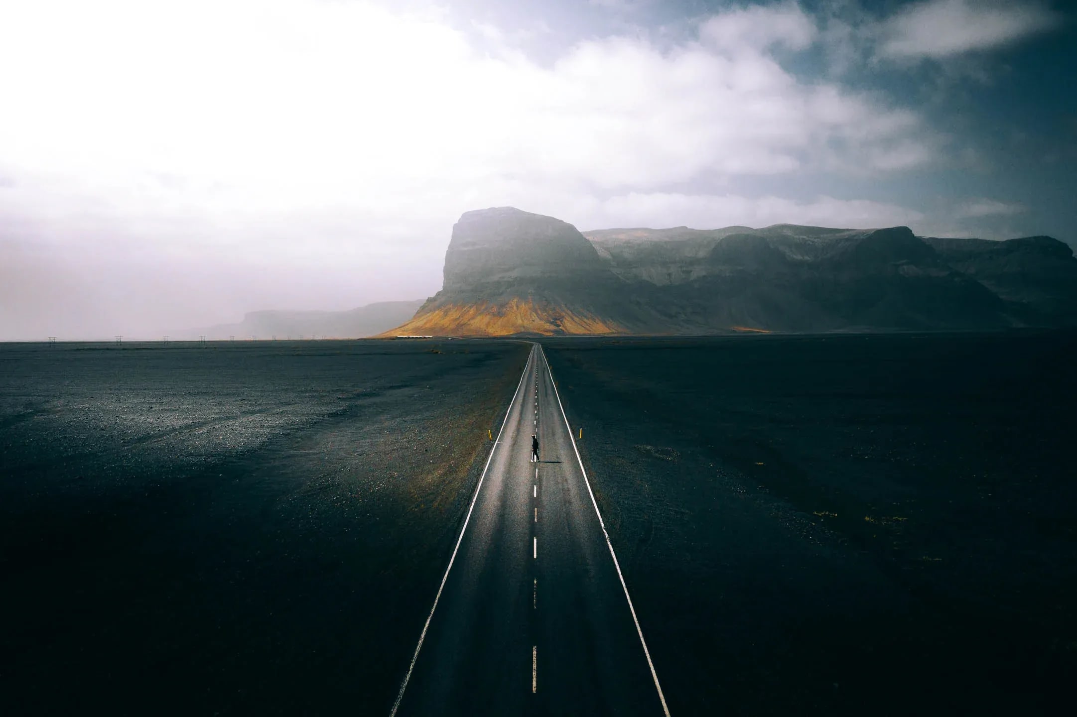 Scenic view of Iceland’s Ring Road crossing a volcanic plain with a towering mountain ahead